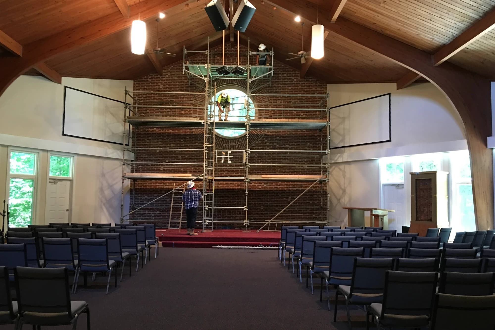 Scaffolding rising to the round window over the exposed brick wall of the sanctuary during the 2016 renovation