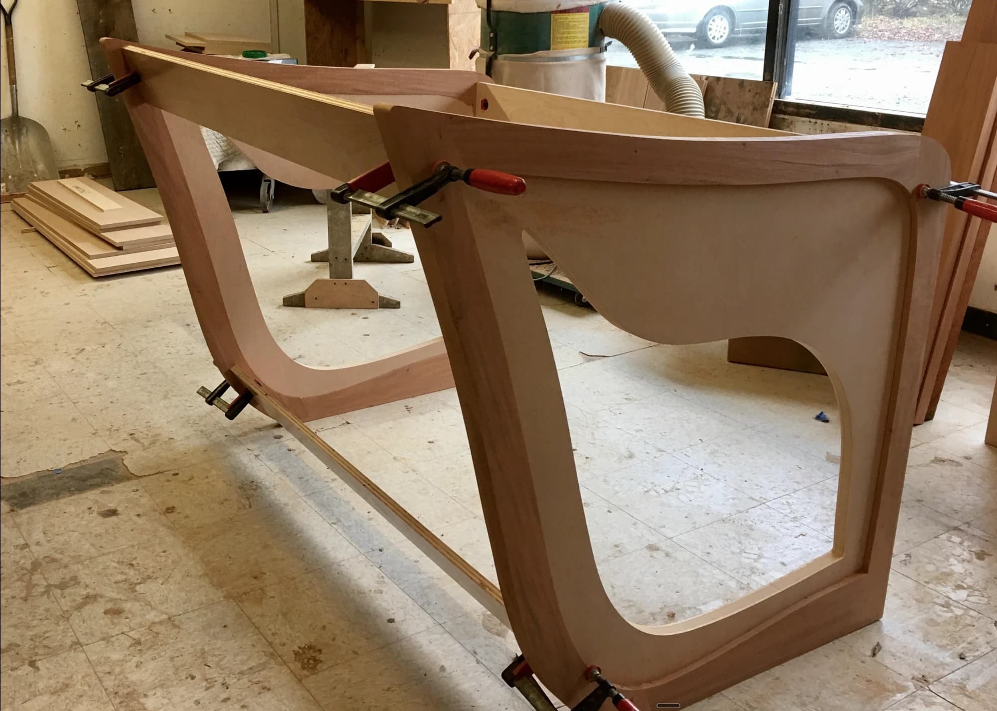 Curved side panels of the new bimah furniture clamped and gluing up in the woodshop