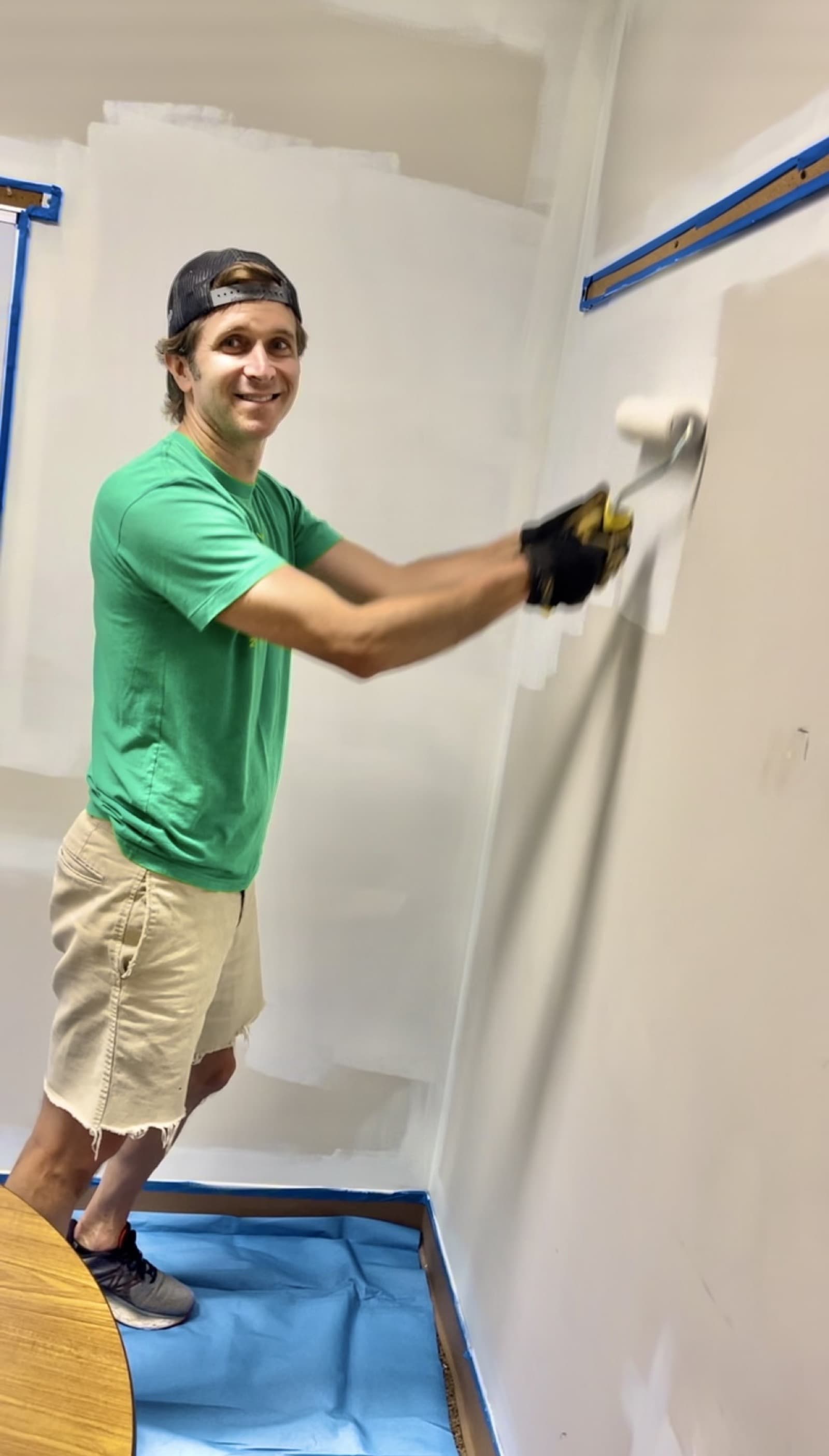 A volunteer rolling fresh paint onto a classroom wall on Mitzvah Day